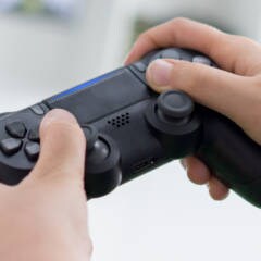 Person hält einen PlayStation-4-Controller