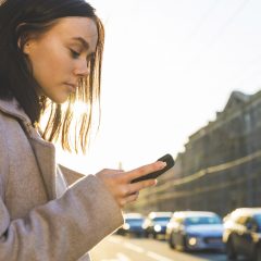 Frau mit Smartphone auf der Straße