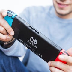 Nintendo Switch Online: Mann spielt mit Blau-Roter-Switch